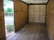 1999 Ford F-800 - The interior of a cargo truck shows plywood walls and a worn wooden floor, with the rear doors shut.