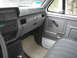 1999 Ford F-800 - The interior of a truck shows the dashboard, door panel, and passenger seat, with a radio and floor mat visible.