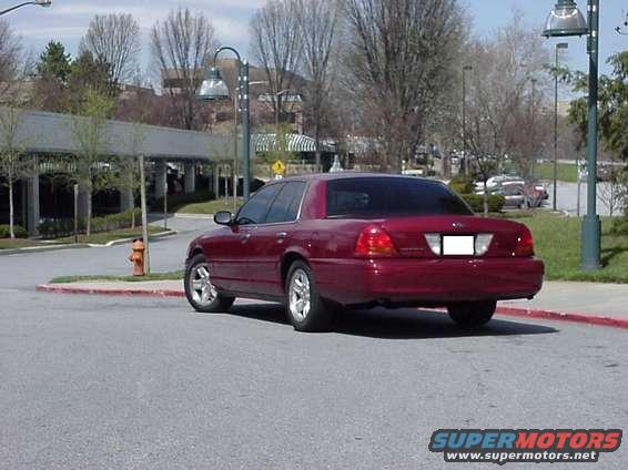 Red sedan, rear view. 2002 Ford Crown Victoria