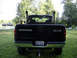 2002 Dodge 2500 - Rear view of a black 2002 Dodge 2500 pickup truck with custom dual exhaust stacks.
