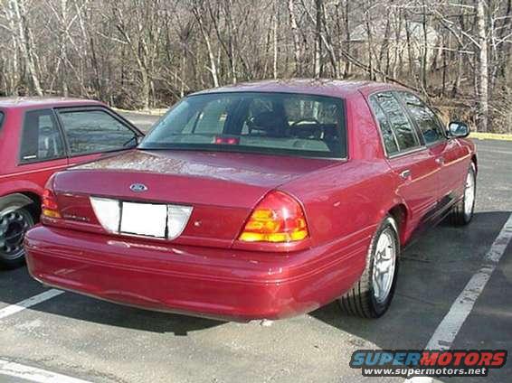 Red 2002 Ford Crown Victoria parked next to another red car