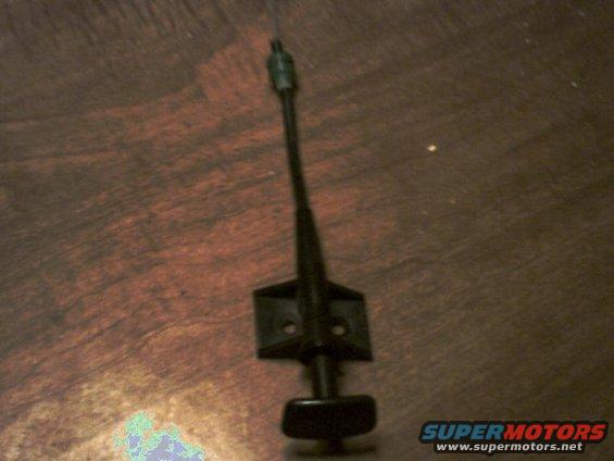 Black car antenna base with mounting bracket on a wooden surface