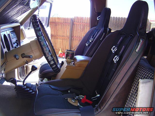 Interior view of a vehicle with racing seats and a manual transmission shifter
