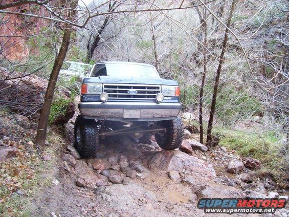 Ford F-Series truck going over rocks on a trail
