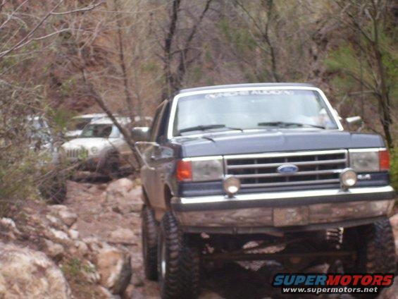 Dark blue 1991 Ford Bronco on a rocky trail with another vehicle behind it