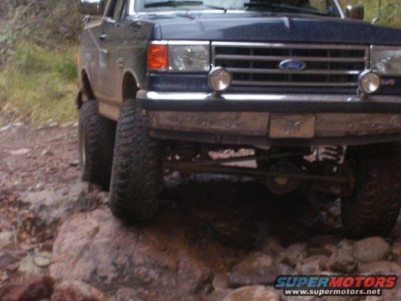 1987 Ford F-Series truck front end, lifted with large tires, on rocks