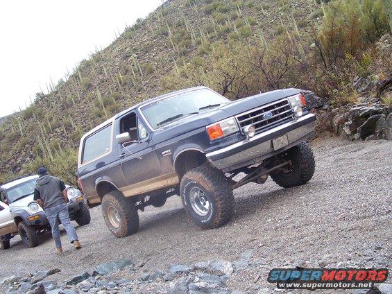 Dark blue lifted Ford Bronco on a rocky trail