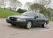 2003 Mercury Marauder - A black 2003 Mercury Marauder is captured in a three-quarter front view while driving on a paved road.