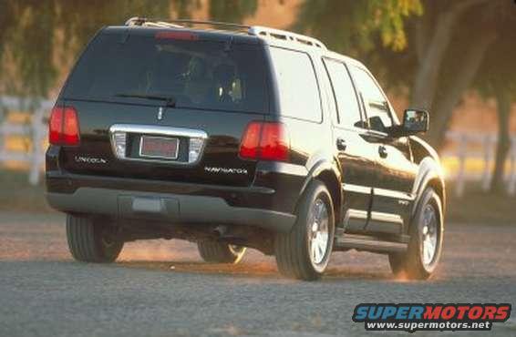 Black Lincoln Navigator driving on a dirt road, rear view