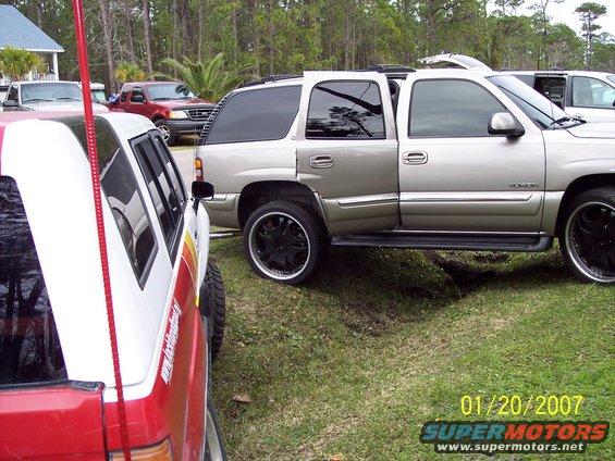 Silver SUV with custom rims parked on grass