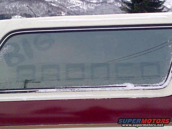 1989 Ford Bronco side window with 'BIG BRONCO' written in the frost, snow on the window frame