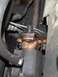 1977 Ford F-150 - A greasy steering linkage component shows a broken bracket, indicating a need for repair.