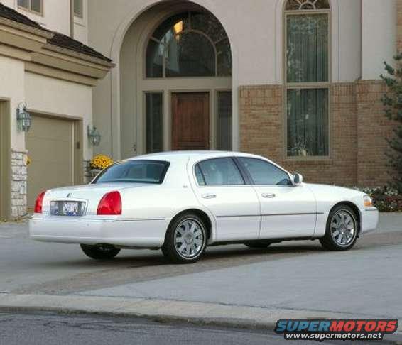 White 2003 Lincoln Town Car parked in front of a house, rear quarter view