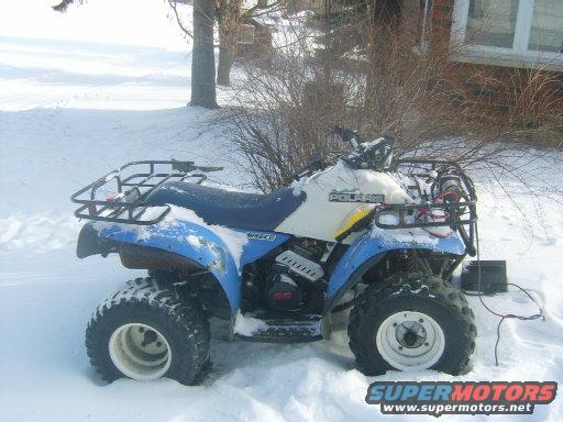 Blue and white Polaris all-terrain vehicle in snow, side view