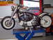 1995 Harley-Davidson Fat Boy - A silver motorcycle is elevated on a blue hydraulic lift, its engine and frame.