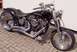1995 Harley-Davidson Fat Boy - A custom black motorcycle with chrome accents is parked on a brick patio in front of a white wall.