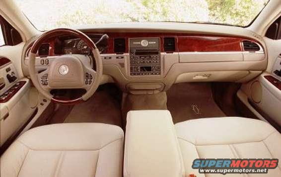 2003 Lincoln Town Car interior with tan leather seats, wood trim, and a beige dashboard