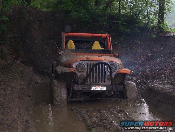Orange Jeep CJ7 stuck in mud, front view. License plate reads DDV 209