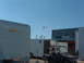 1994 Jeep YJ - Several trailers and utility vehicles are parked under a clear blue sky with a helicopter flying overhead.