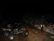 2005 Honda TRX 450 R - Two ATVs are parked on a dirt road at night, with a person standing near one of them.
