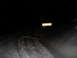 2005 Honda TRX 450 R - An ATV navigates a snowy trail at night, illuminated by a nearby sign.
