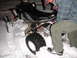 2005 Honda TRX 450 R - A black 2005 Honda TRX 450 R ATV is stuck in the snow, with a person in winter attire observing it.
