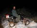2005 Honda TRX 450 R - Man on a black 2005 Honda TRX 450 R ATV in the snow at night with a red cooler on the back.