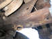1968 Ford Bronco - Underside view of a vehicle's rusty frame and suspension components, with a tire visible at the bottom.