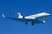 1990 Ford Mustang - A white private jet with registration N680GA is captured in flight against a clear blue sky.