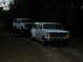 1986 Ford F-350 - A white dually truck tows a white SUV at dusk.