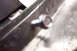 1968 Ford Mustang - A close-up view shows a bolt secured to a metal bracket, likely part of a vehicle's assembly.