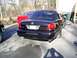 2003 Mercury Marauder - A black 2003 Mercury Marauder sedan is parked on an asphalt driveway next to a red car.