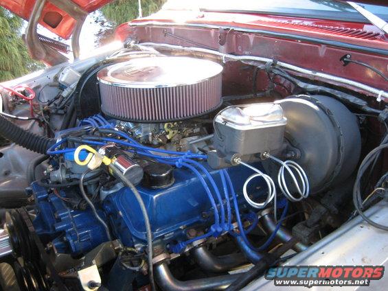 Engine bay with blue spark plug wires and a large air filter