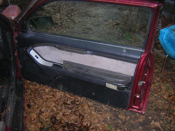 1987 Ford Thunderbird interior door panel with fabric insert and armrest