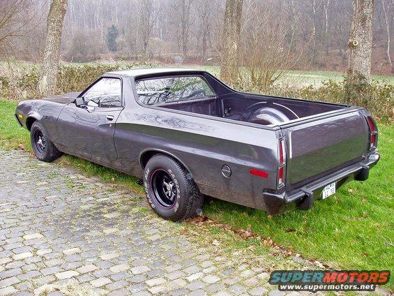 Dark gray 1972 Ford Ranchero parked on cobblestone and grass