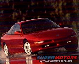 Red 1989 Ford Probe driving through water, front 3/4 view