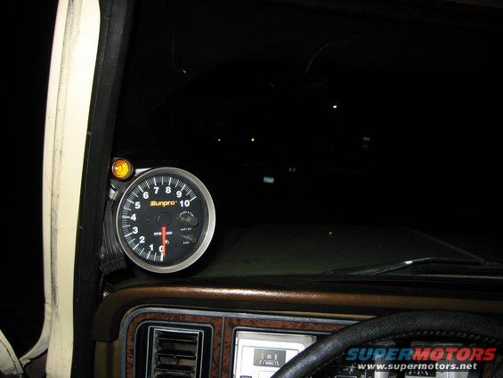 Tachometer gauge mounted on dashboard of a vehicle interior