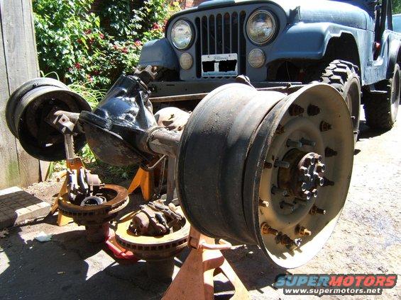 Jeep front axle assembly and wheels on jack stands in front of the vehicle