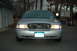2003 Ford Crown Victoria - This 2003 Ford Crown Victoria is parked in a driveway with a house and trees in the background.