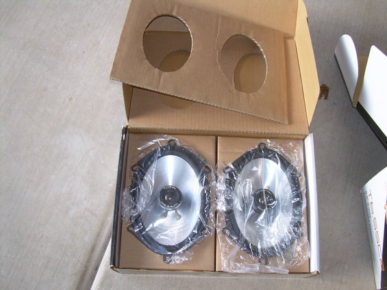 two oval car speakers in a cardboard box