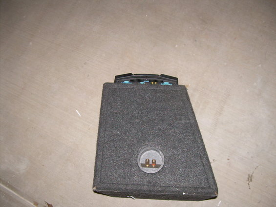 Car amplifier and speaker enclosure on a concrete floor