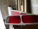 1996 Ford Probe - A pair of red and clear car tail lights are stored in a garage, possibly for a project or repair.