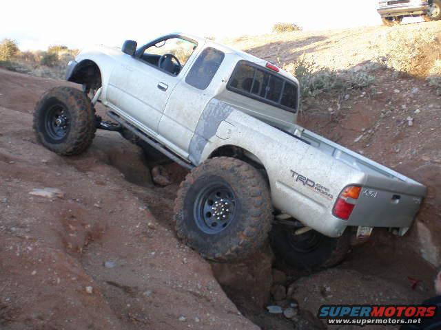 Silver Toyota Tacoma TRD off-road climbing rocks