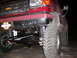 1991 Ford Bronco - Close-up of a lifted 1991 Ford Bronco's front suspension and large off-road tires.