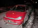 2002 Ford Focus - A red hatchback is parked on a snow-covered street at night, with another vehicle behind it.