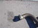 1996 Ford Probe - A clamp secures a section of exhaust pipe resting on a concrete surface.