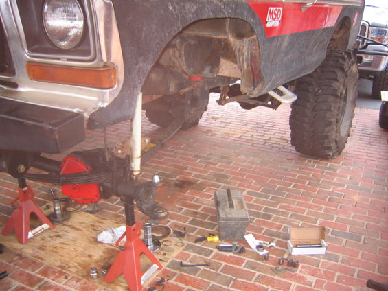 1979 Ford Bronco front axle disassembled on jack stands, with MSD ignition decal visible on fender