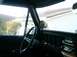 1978 Ford Bronco - View from inside a vehicle, looking towards the dashboard and out the side window.