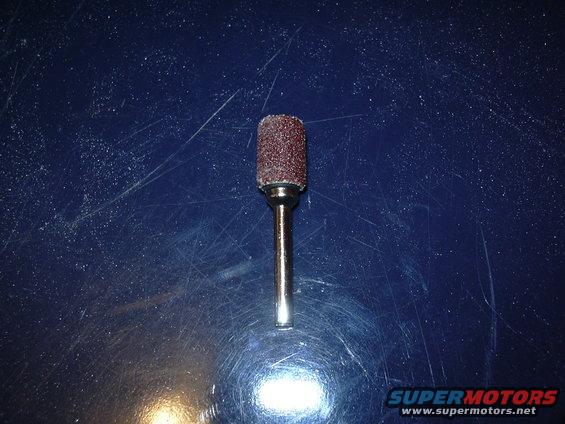 Sanding drum bit on blue surface