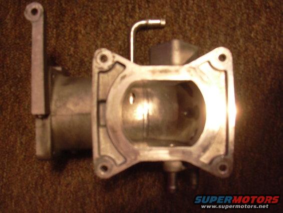 Close-up of a throttle body with a lever arm and a metal tube